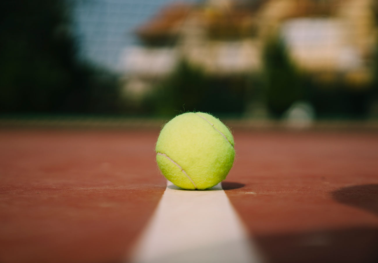 Close-up of a tennis ball on a line (half in / half out) Symbolizes deciding points, precision, and margins that matter.
